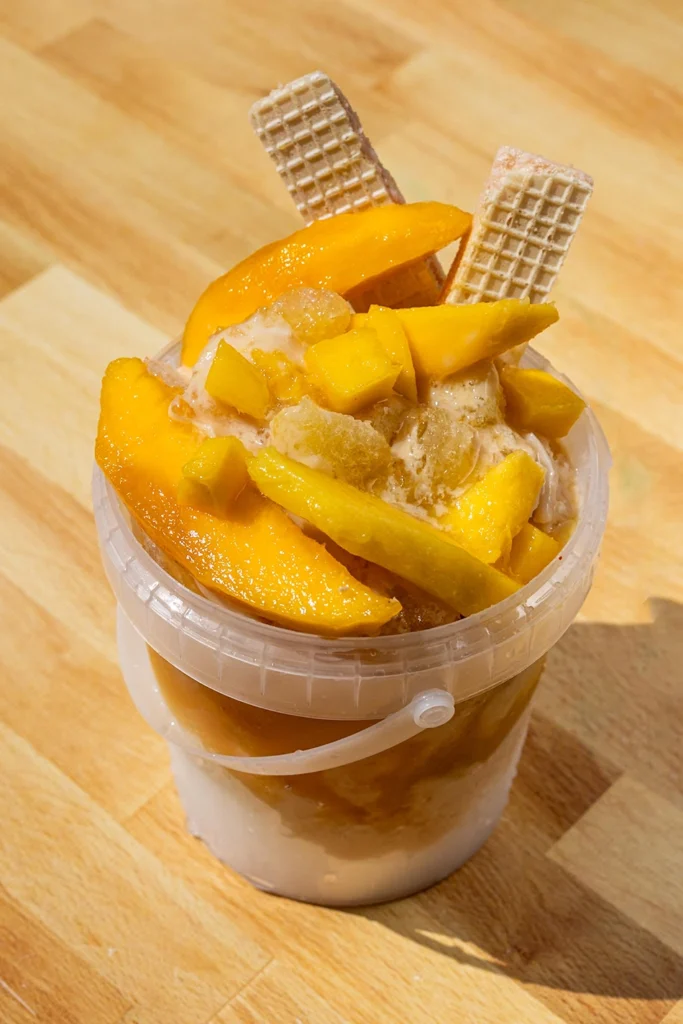Loaded mango raspado bucket with fresh mango and wafer cookies